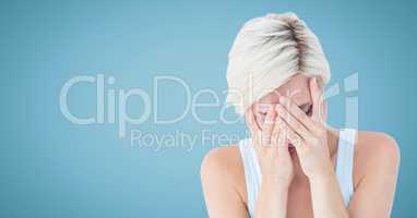 Woman crying in hands against blue background