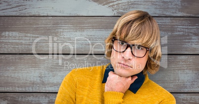 Male hipster wearing eyeglasses against wooden wall