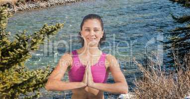 Double exposure of woman with hands clasped performing yoga by lake