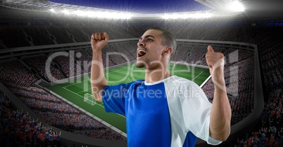 Happy soccer player celebrating victory against stadium
