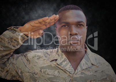 Soldier saluting against black grunge background
