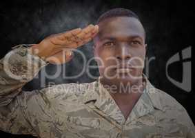 Soldier saluting against black grunge background