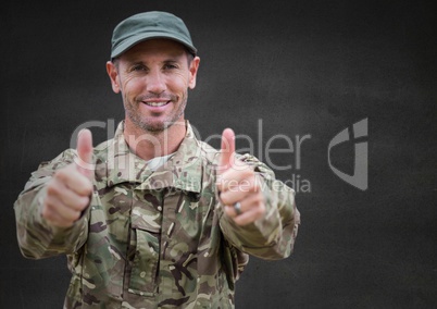 Soldier thumbs up against grey wall