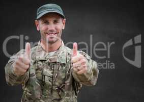 Soldier thumbs up against grey wall
