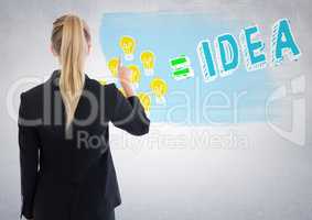 Back of business woman pointing at lightbulb doodle against white wall