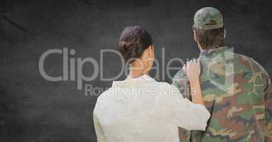 Back of soldier and wife against grey wall with grunge overlay