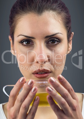 Close up of woman drinking tea against grey background