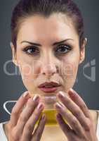 Close up of woman drinking tea against grey background