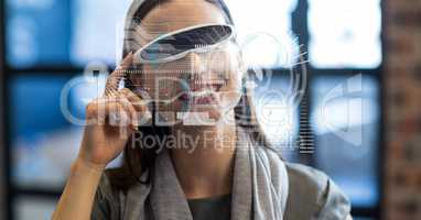 Digitally generated image of various icons with businesswoman using VR glasses in office