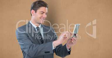 Smiling businesswoman using smart phone against brown background