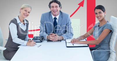 Happy business people at desk against graph