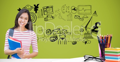 Smiling student holding books against graphics