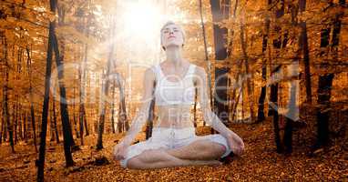 Double exposure of woman meditating in autumn forest