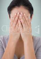 Woman with hands on face against light blue background