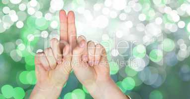 Close-up of hands against green glowing bokeh