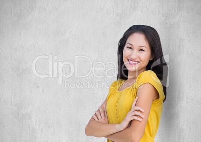 Smiling woman with arms crossed against wall