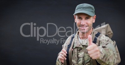 Soldier thumbs up against navy chalkboard