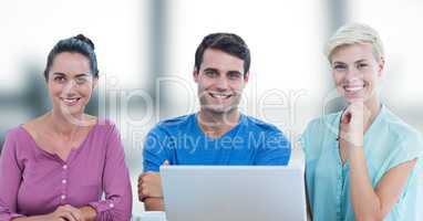 Portrait of smiling businesspeople with laptop in office