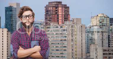 Confident male hipster with arms crossed against buildings