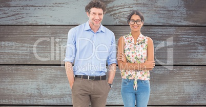 Casual business colleagues standing against wooden wall