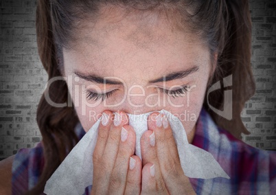 Close up of woman blowing nose against white brick wall with grunge overlay