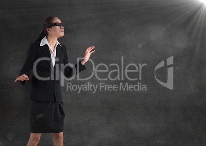 Business woman blindfolded with grunge overlay against grey wall and flare