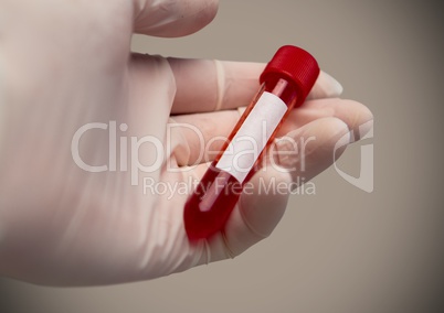 Gloved hand with red container against brown background