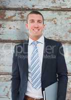 Businessman smiling over wooden wall