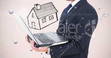 Midsection of businessman holding laptop with house drawn in background
