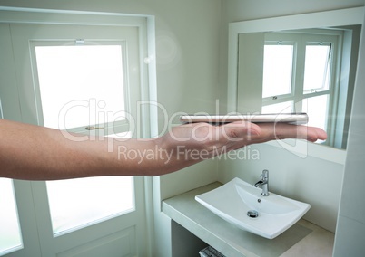 Hand holding phone in bathroom