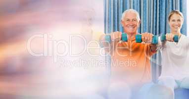 Senior man with woman lifting dumbbells in gym