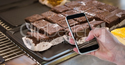 Hand photographing brownie on smart phone