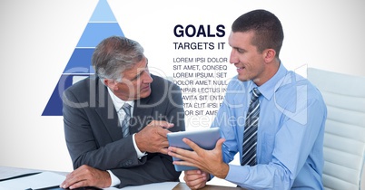 Businessmen discussing over tablet PC against graph and text