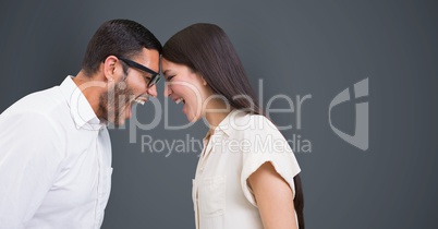 Angry business people with head to head screaming against gray background