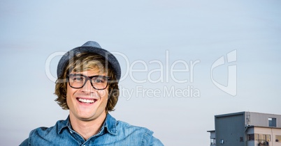 Happy male hipster smiling against clear sky