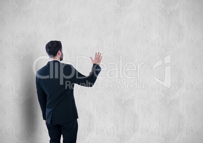 Rear view of businessman gesturing against wall