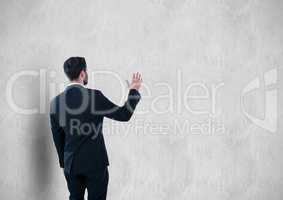 Rear view of businessman gesturing against wall
