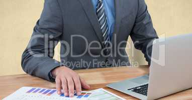 Midsection of businessman using laptop at desk