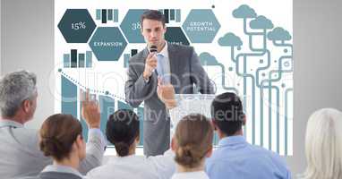 Businessman giving presentation to colleagues with graphics in background