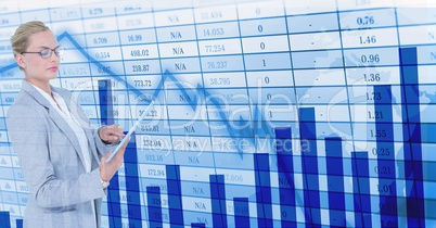 Businesswoman using digital tablet by screen Businesswoman using digital tablet by screen