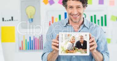 Happy businessman showing man and woman on tablet PC's screen in office