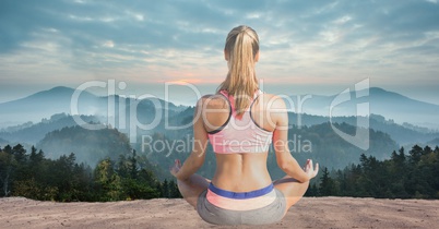 Double exposure of woman meditating against mountains