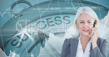 Businesswoman using mobile phone against success clock