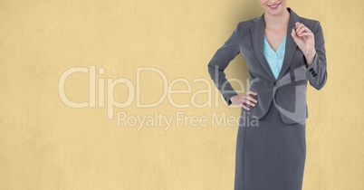 Midsection of businesswoman writing over beige background