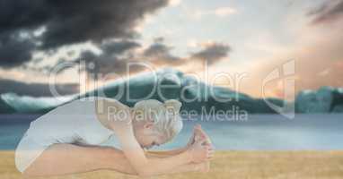 Double exposure of fit woman doing yoga at beach
