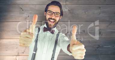 Hipster showing thumbs up against wall