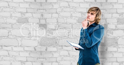 Thoughtful hipster holding digital tablet against wall