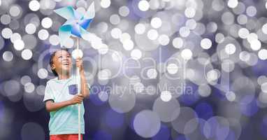 Happy boy holding pinwheel over bokeh