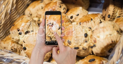 Hands taking picture of cupcakes with smart phone