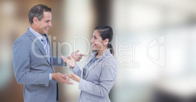 Happy business people talking against blurred background